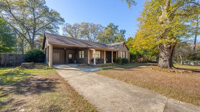 a view of a house with backyard and trees