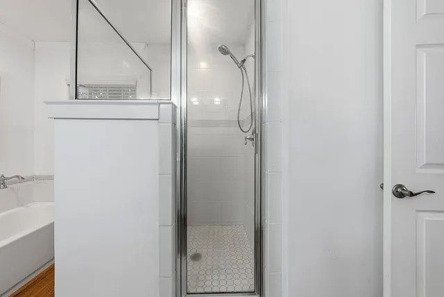 a bathroom with a glass shower door and mirror
