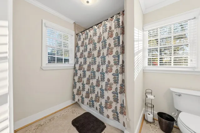 a bathroom with a toilet and a shower curtain