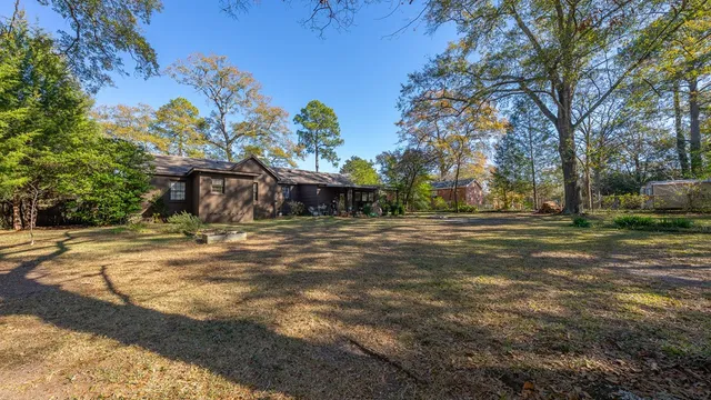 a front view of a house with a yard and trees