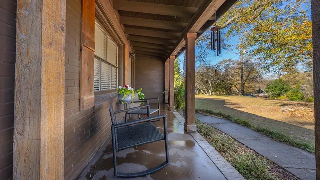 a porch with a table and chairs and potted plants