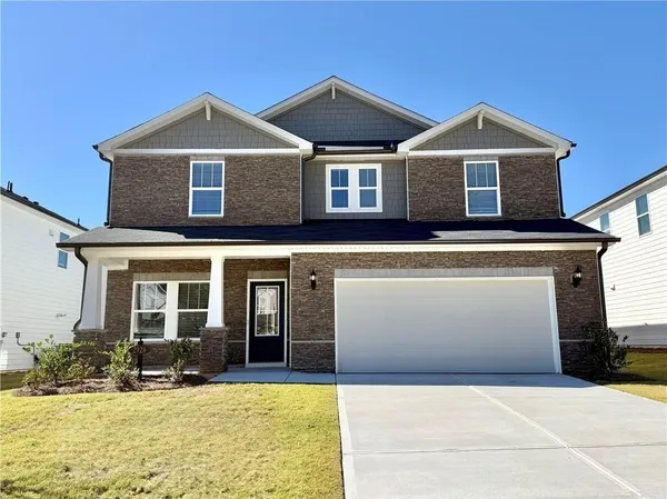 a front view of a house with yard and parking space