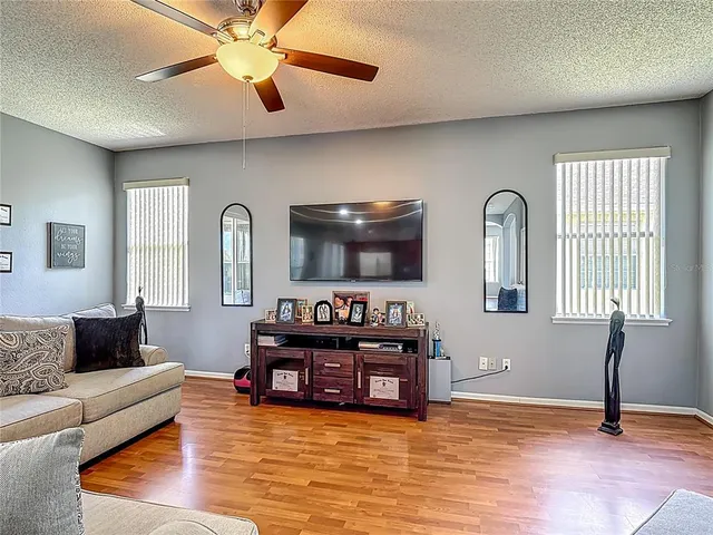 a living room with furniture and a ceiling fan