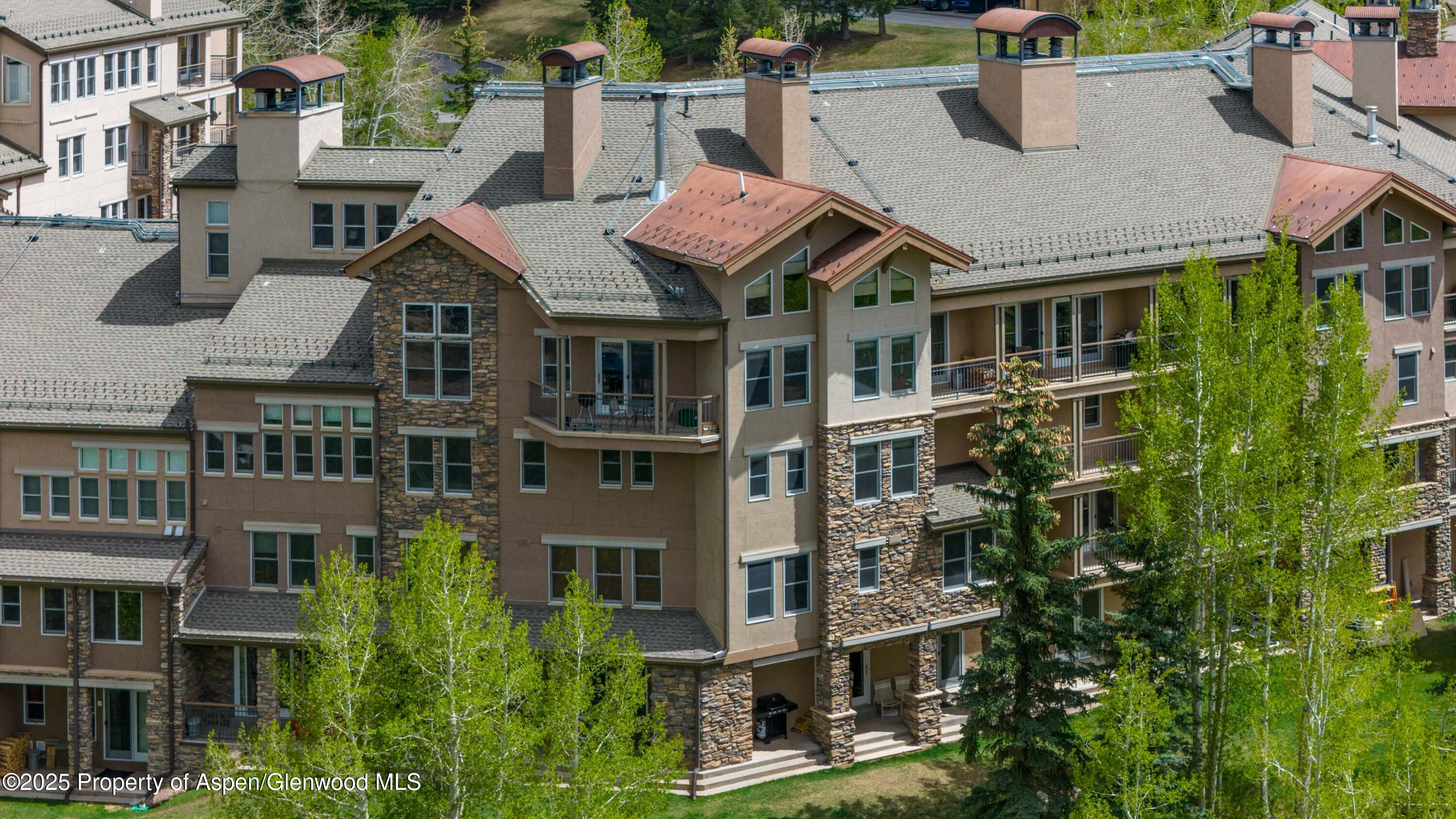 425 Wood Road, Unit 48 Snowmass Village, CO 81615 - Photo 2 of 41 a front view of a residential apartment building with a yard