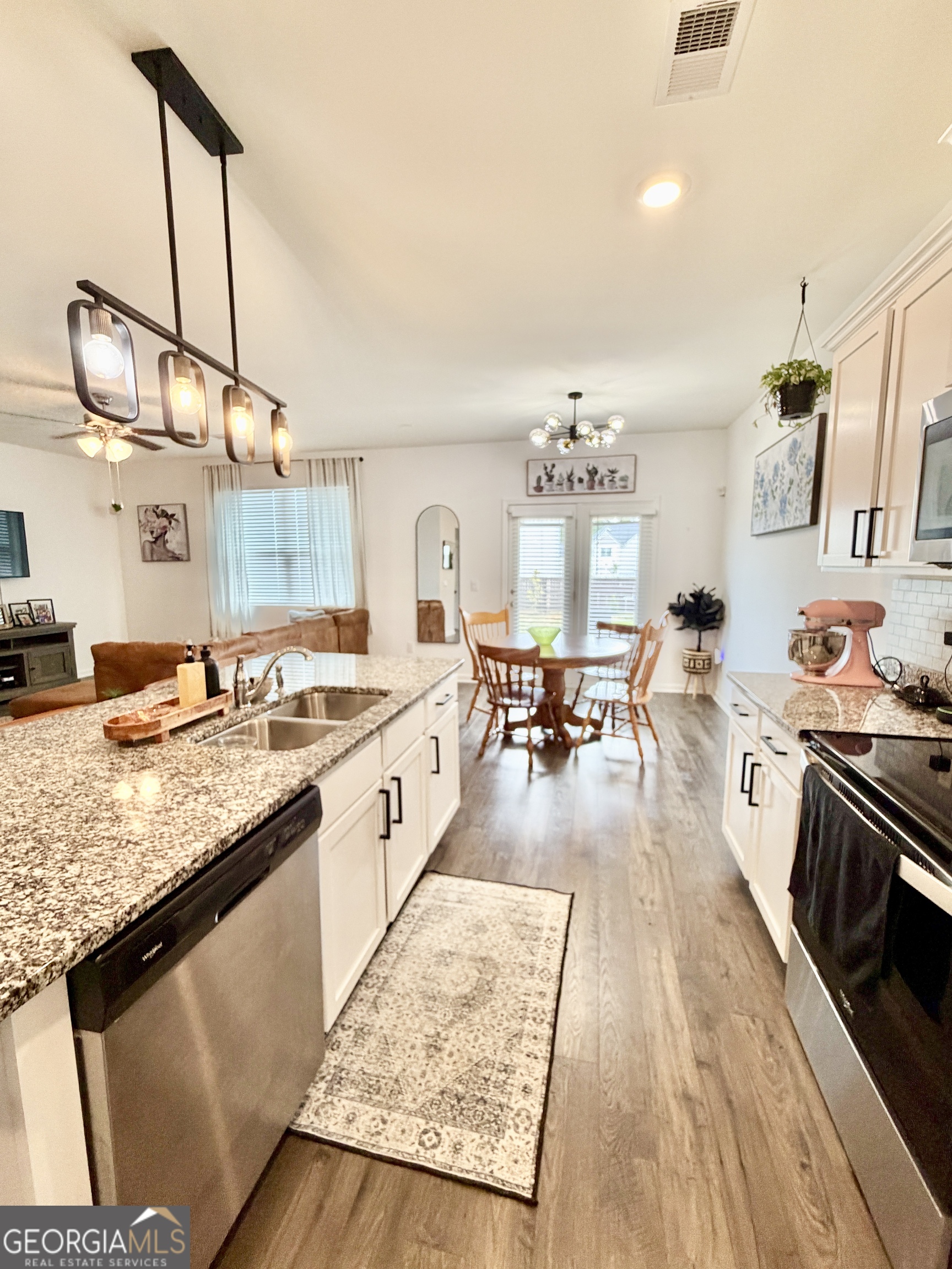 219 Barnyard Way Perry, GA 31069 - Photo 9 of 44 a large kitchen with sink stove and a wooden floor