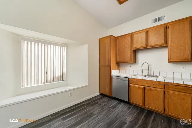 a kitchen with stainless steel appliances granite countertop a sink and cabinets with wooden floor
