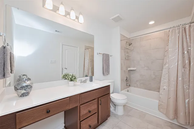 a bathroom with a double vanity sink toilet mirror and shower