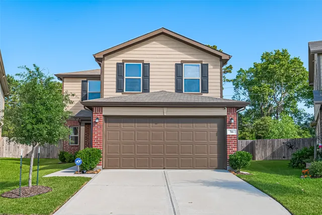 a front view of a house with yard and trees