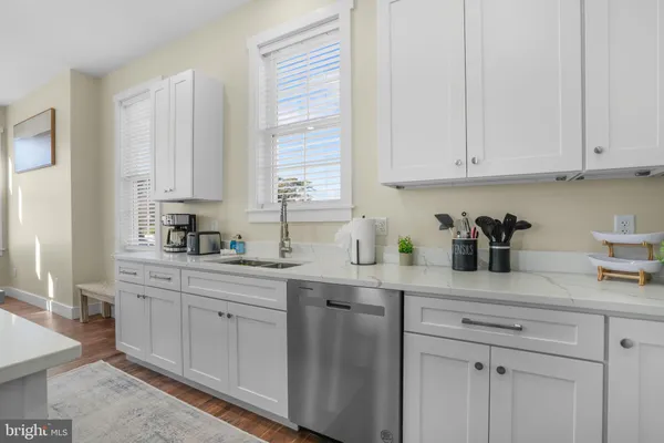 a kitchen with white cabinets and sink