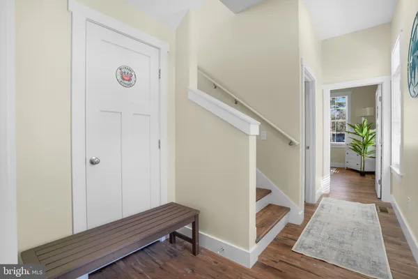 a view of front door with wooden floor and stairs