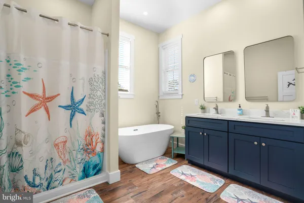 a bathroom with a bathtub sink vanity mirror and toilet