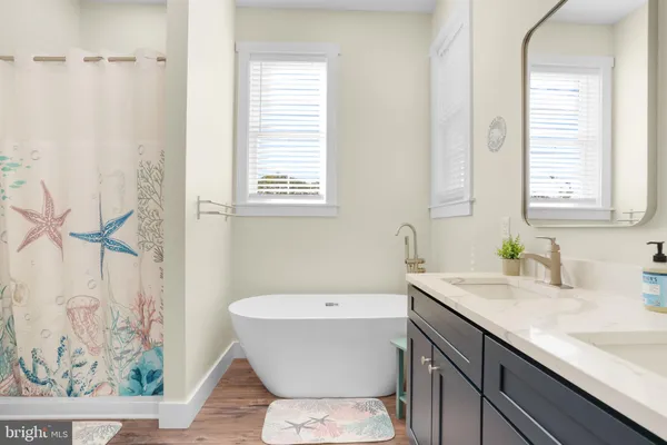 a bathroom with a sink a toilet a window and a mirror