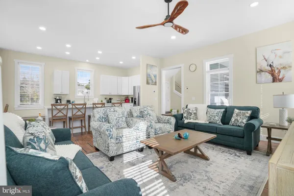 a living room with furniture and a view of kitchen