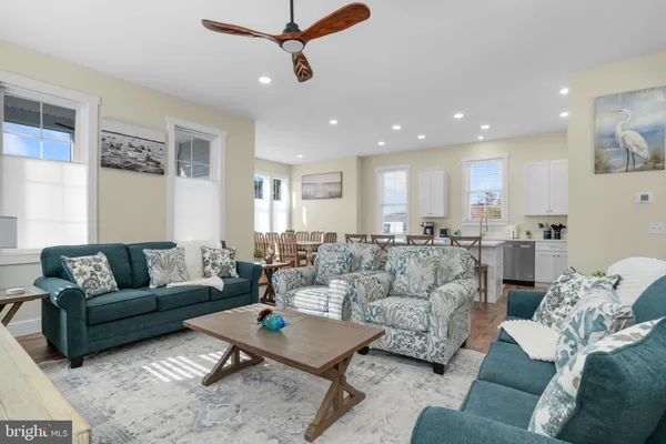 a living room with furniture and a view of kitchen