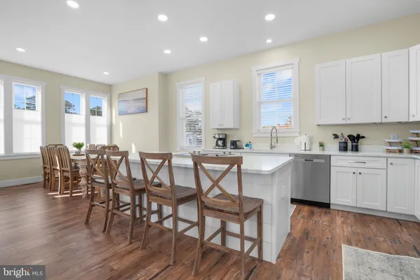 a kitchen with a dining table chairs and white cabinets