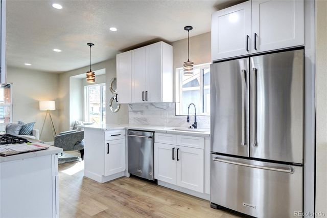 a kitchen with stainless steel appliances a refrigerator sink and cabinets