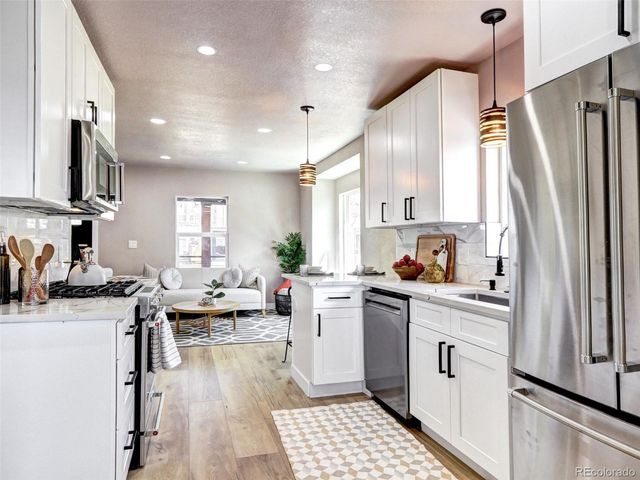 a kitchen with white cabinets and appliances