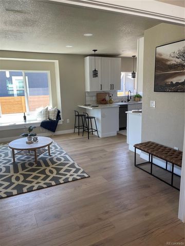 a living room with kitchen furniture and a table
