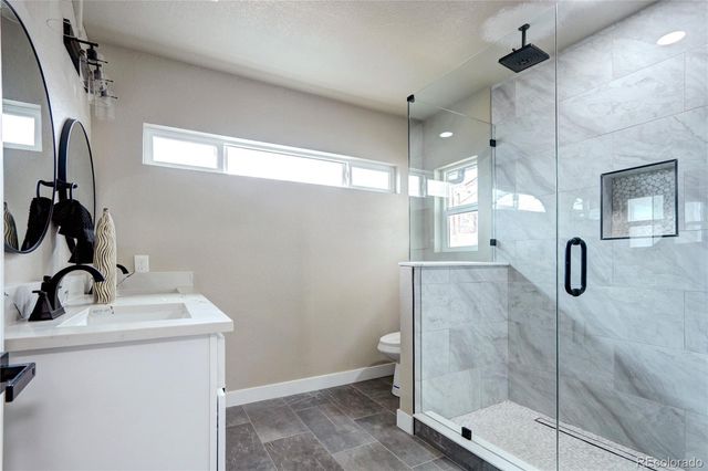 a bathroom with a sink mirror and shower