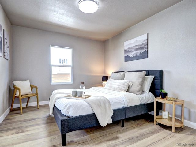 a bedroom with bed and wooden floor