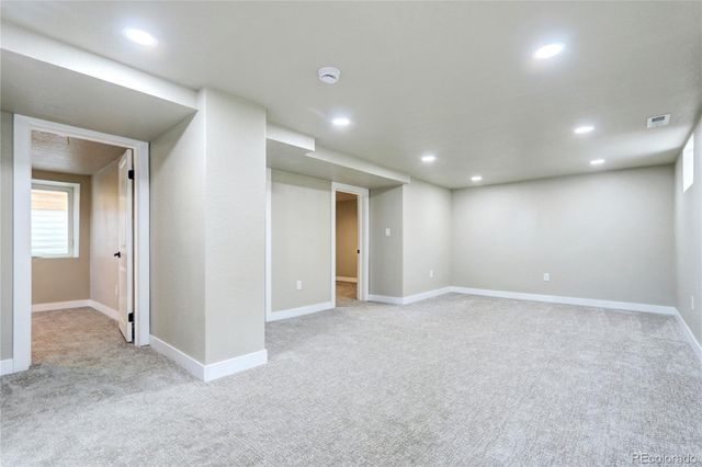 an empty room with windows and entrance to other room