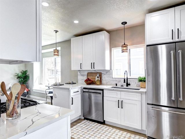 a kitchen with white cabinets and stainless steel appliances