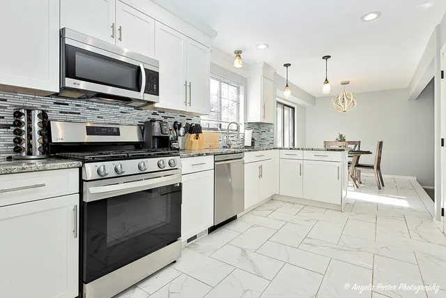 a kitchen with stainless steel appliances a stove microwave and cabinets