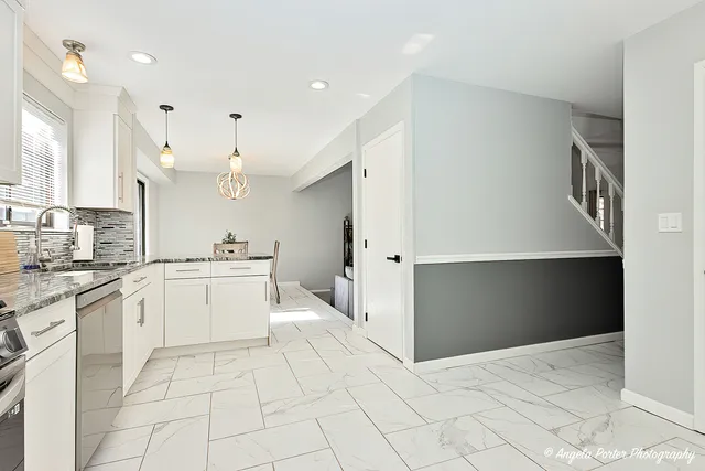 a large white kitchen with a stove a sink dishwasher and a refrigerator