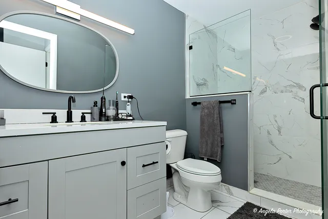 a bathroom with a toilet a sink and mirror