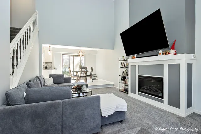 a living room with furniture a flat screen tv and a fireplace