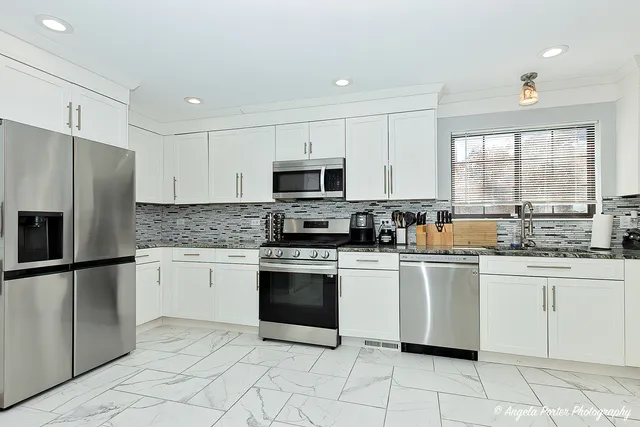 a kitchen with granite countertop cabinets stainless steel appliances and a counter space