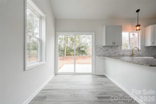 a view of a kitchen with wooden floor and a window