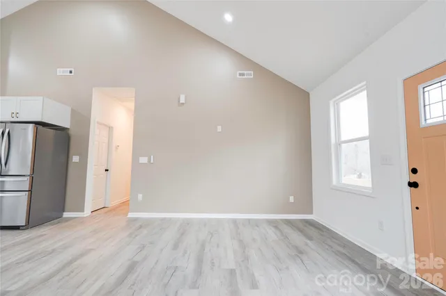 an empty room with wooden floor and a window
