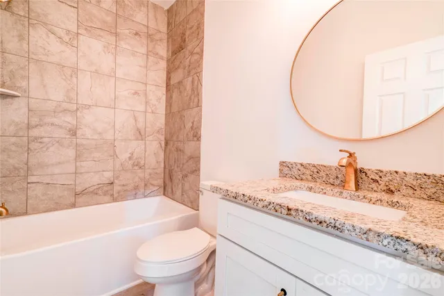 a bathroom with a granite countertop sink a toilet and bathtub