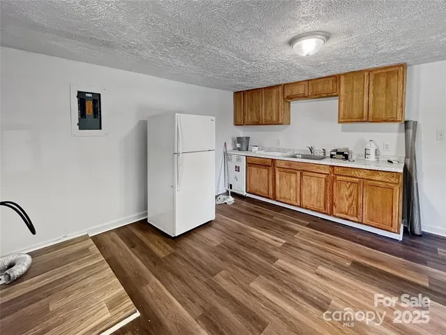 a kitchen with granite countertop a stove a sink and a refrigerator