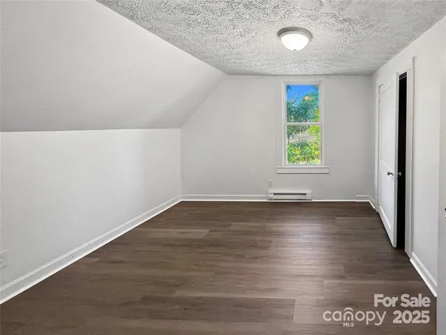 an empty room with wooden floor and a window