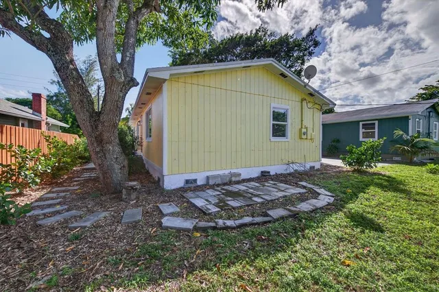 a view of a backyard with plants and large trees