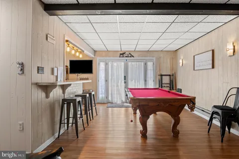 a room with stainless steel appliances kitchen island granite countertop a table chairs refrigerator and sink