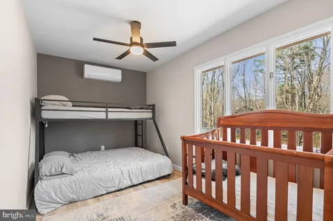 a bedroom with a large bed and a chandelier fan