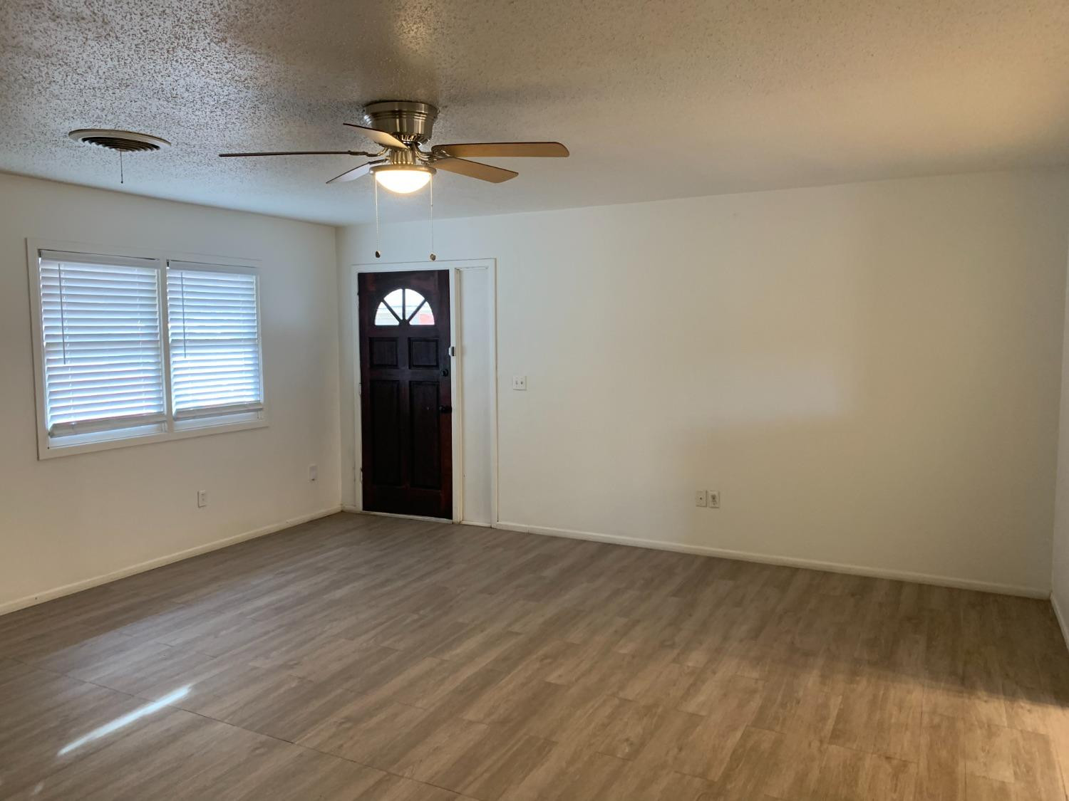 4316 58th Street, Unit B Lubbock, TX 79413 - Photo 12 of 30 wooden floor in an empty room with a window