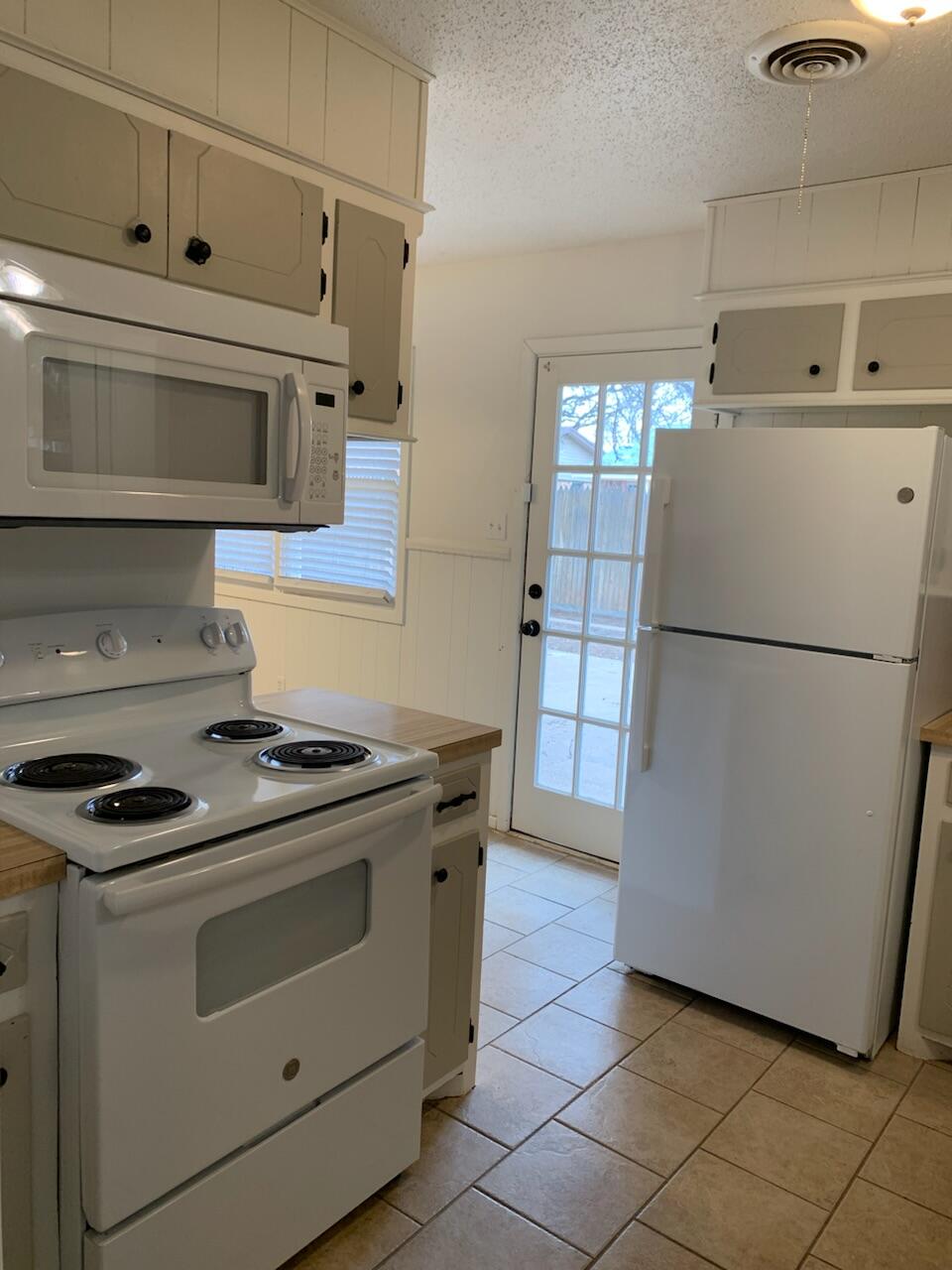 4316 58th Street, Unit B Lubbock, TX 79413 - Photo 17 of 30 a kitchen with a stove top oven and refrigerator