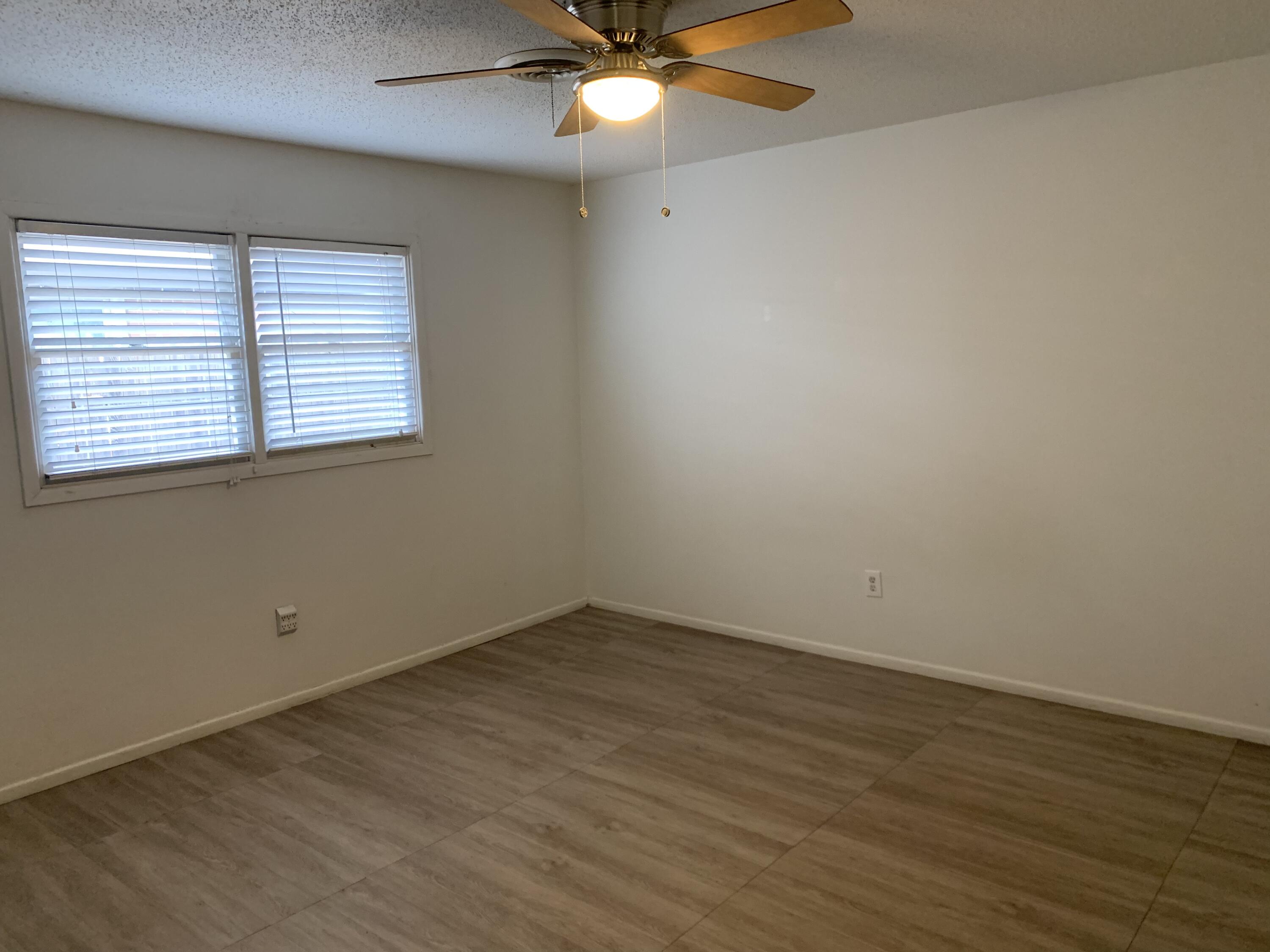 4316 58th Street, Unit B Lubbock, TX 79413 - Photo 20 of 30 an empty room with wooden floor and windows
