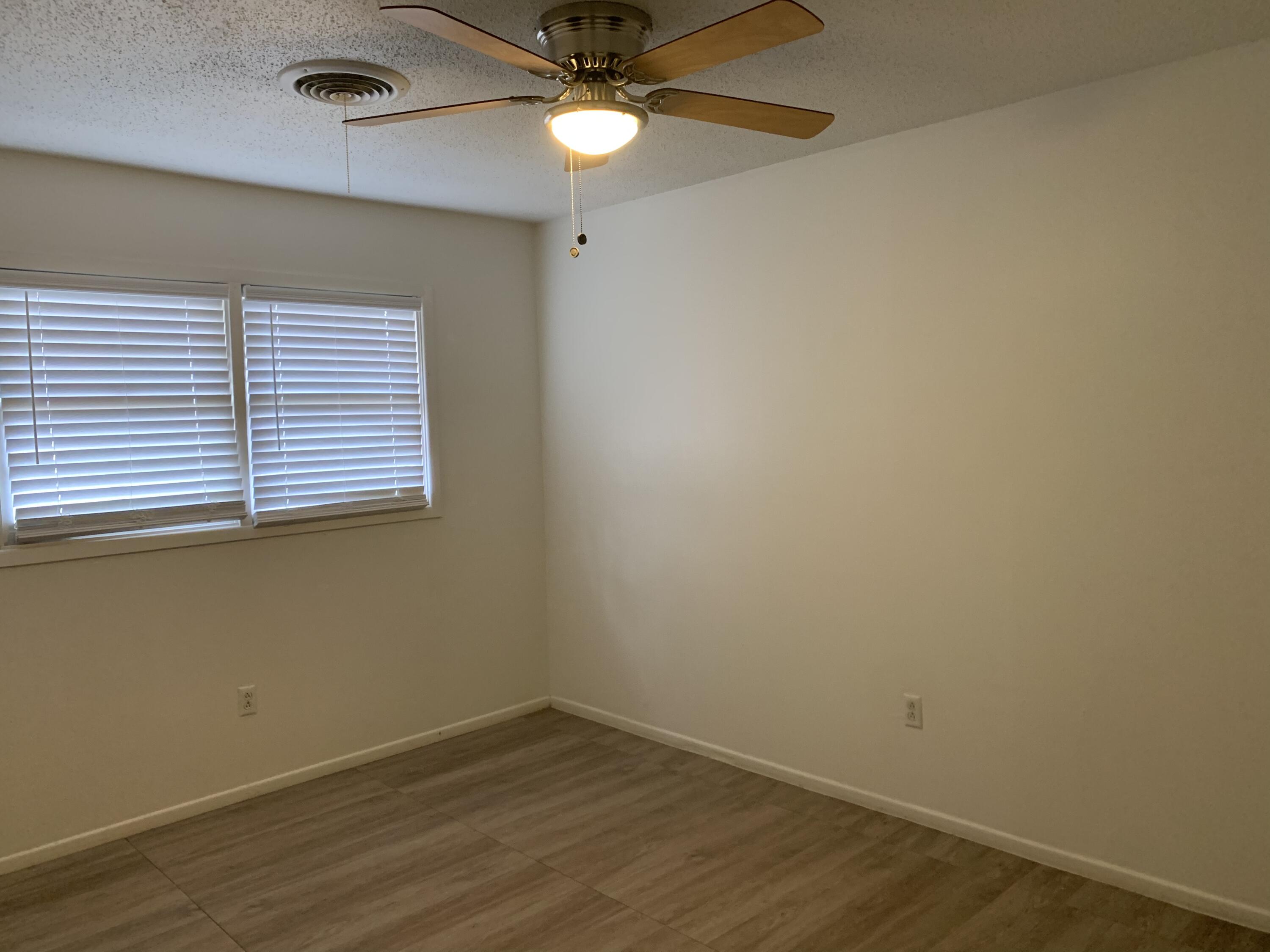 4316 58th Street, Unit B Lubbock, TX 79413 - Photo 24 of 30 an empty room with wooden floor and fan