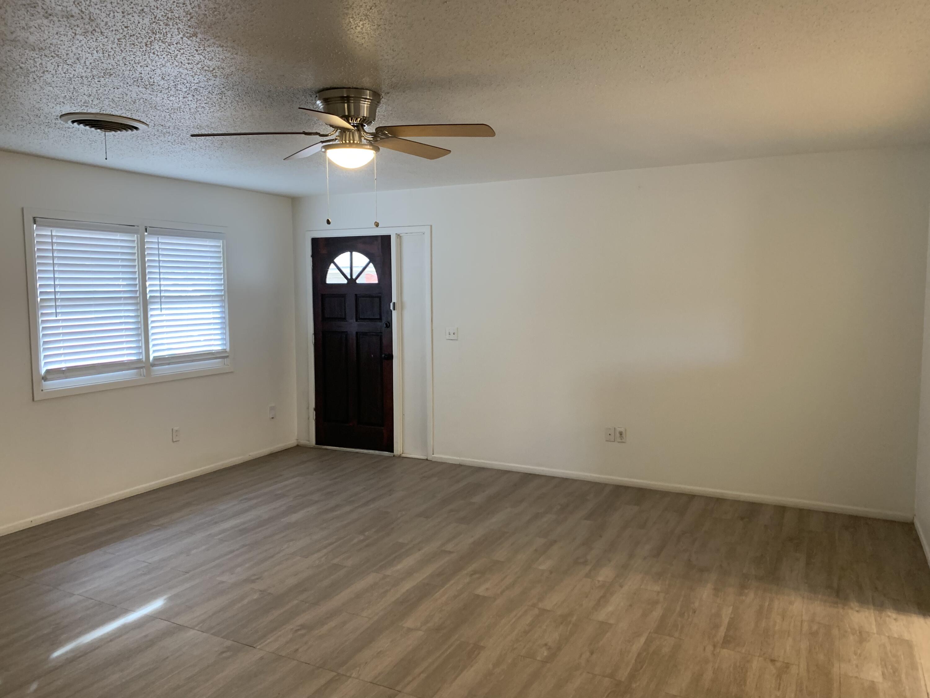 4316 58th Street, Unit B Lubbock, TX 79413 - Photo 27 of 30 wooden floor in an empty room with a window