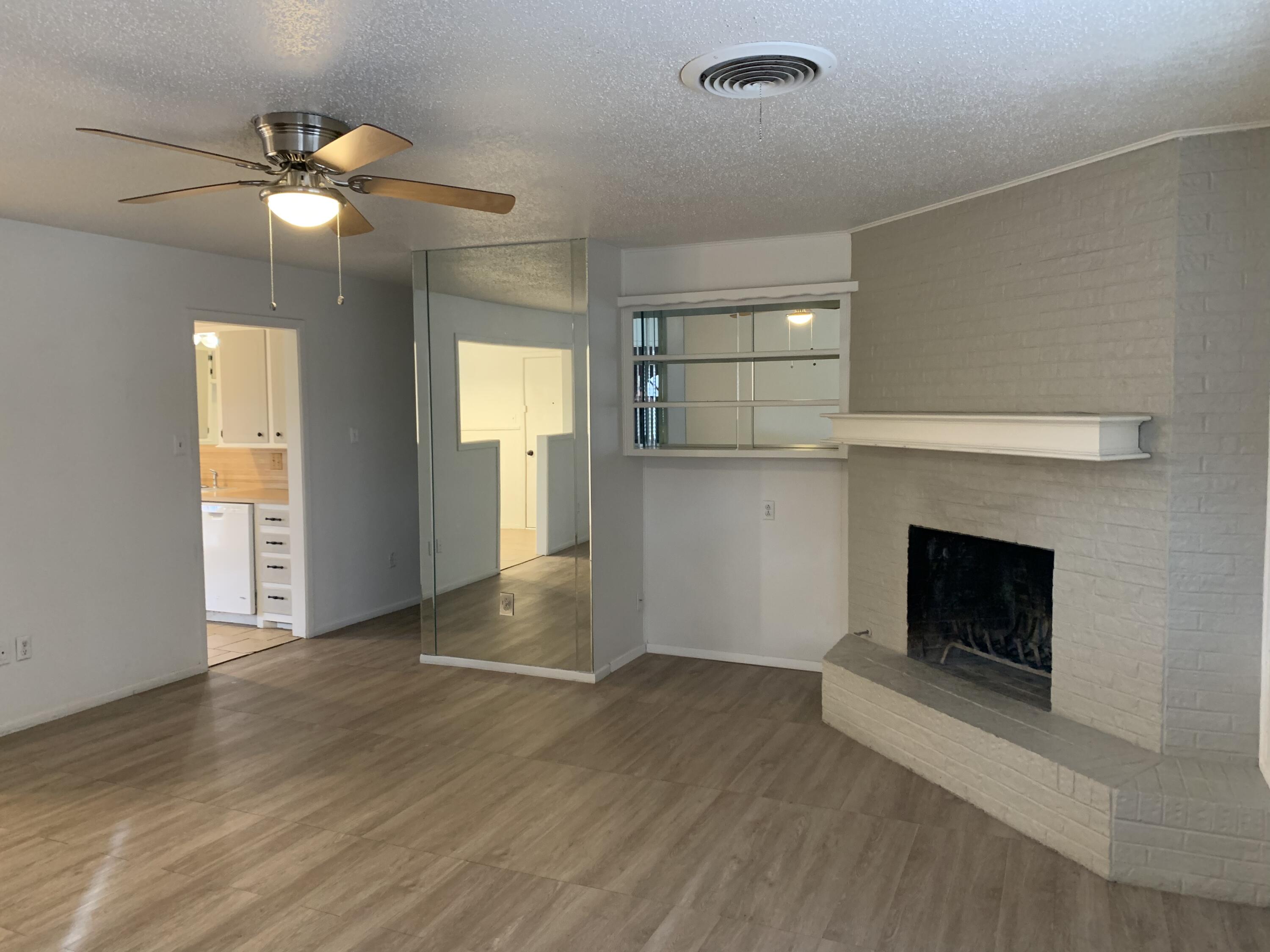 4316 58th Street, Unit B Lubbock, TX 79413 - Photo 28 of 30 a view of an empty room with wooden floor and a fireplace