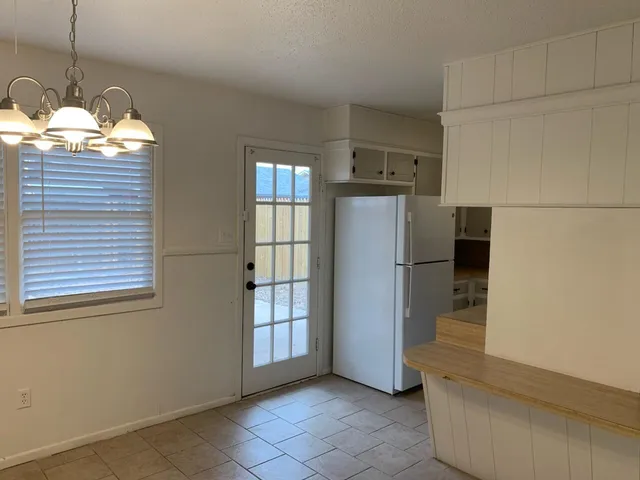 a open kitchen with refrigerator and window