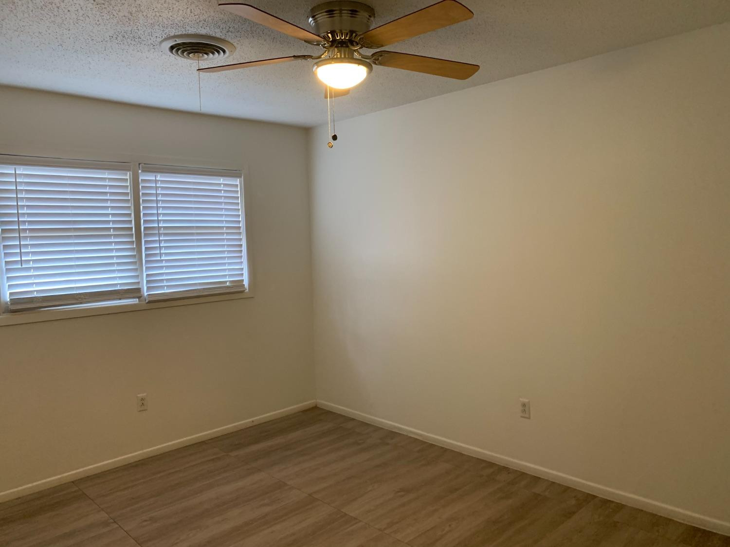 4316 58th Street, Unit B Lubbock, TX 79413 - Photo 9 of 30 an empty room with wooden floor and fan