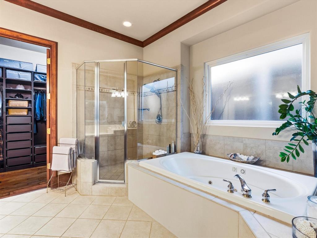 1615 Roma Lane Allen, TX 75013 - Photo 15 of 36 Spacious bathroom featuring a built-in jetted tub, a glass-enclosed shower with tiled walls, and light-toned tile flooring