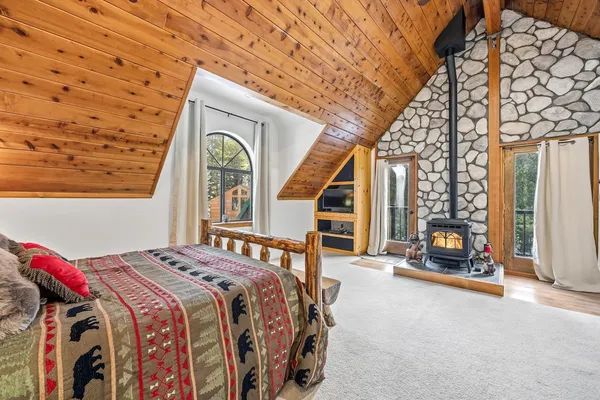 a bedroom with a bed and a large window with the outer view