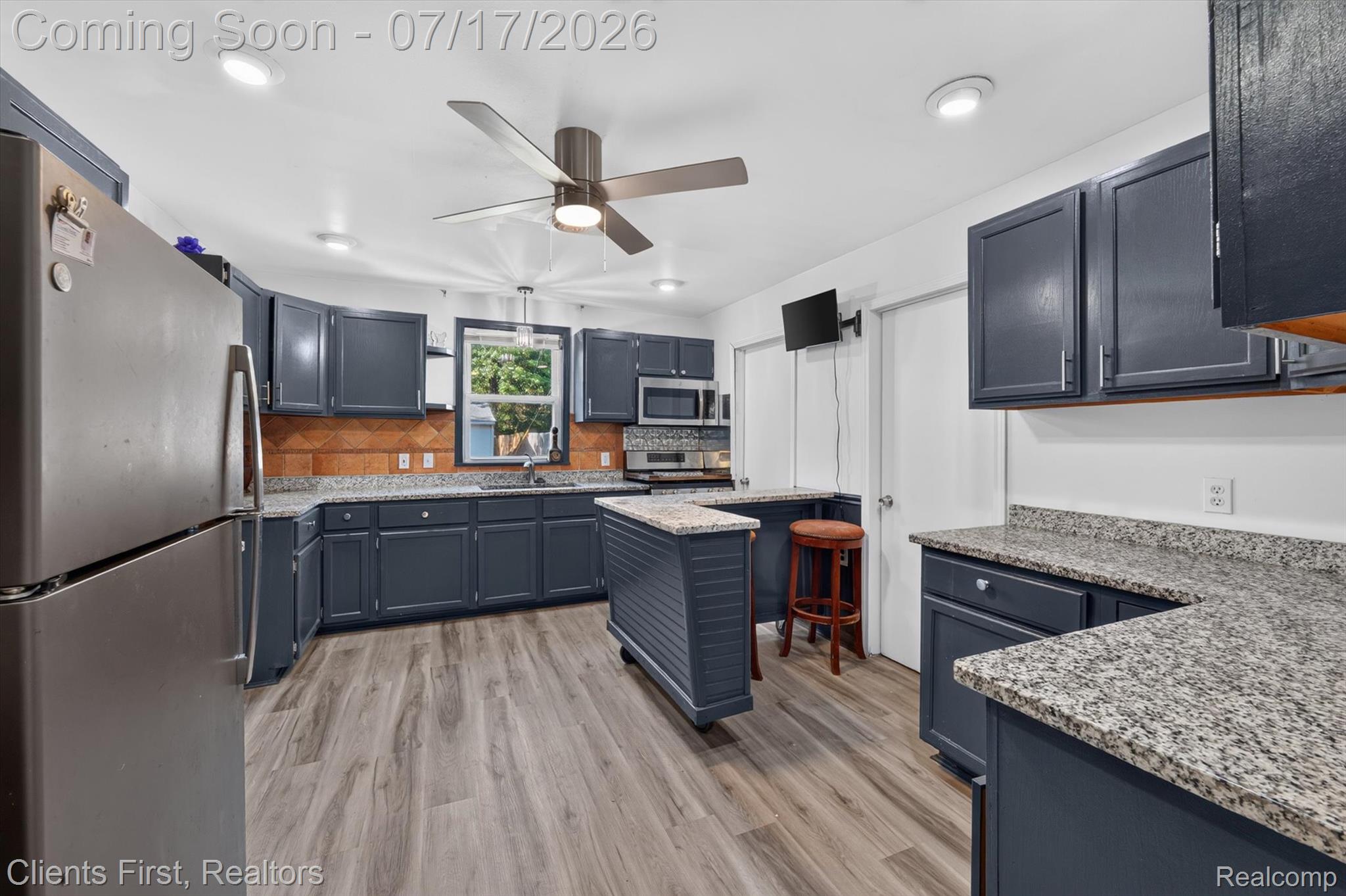 36852 Chase Street Romulus, MI 48174 - Photo 10 of 40 Kitchen featuring dark cabinetry, granite-finish countertops, and wood-finish flooring